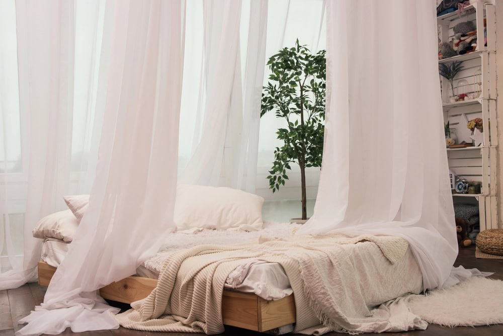 bedroom with sheer curtains surrounding the bed romantic