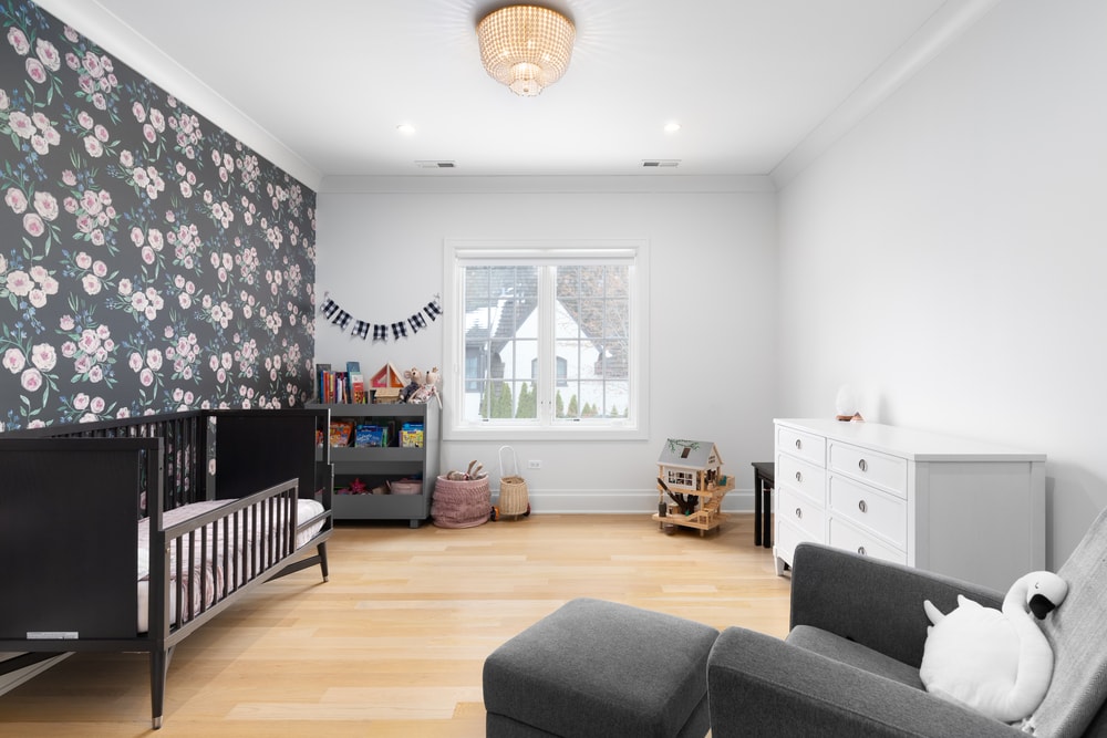 babies room with floral accent wall